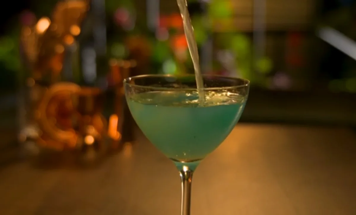 Pale blue signature cocktail being poured into a coupe glass at the CATCH Las Vegas bar