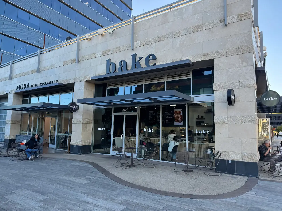 Stone storefront of bake The Cookie Shoppe beside Mora Iced Creamery with patio seating at Downtown Summerlin