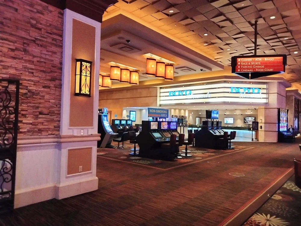 Aliante casino floor near FARM with stacked-stone columns, lantern sconces, slot machines, and Boyd Rewards signage