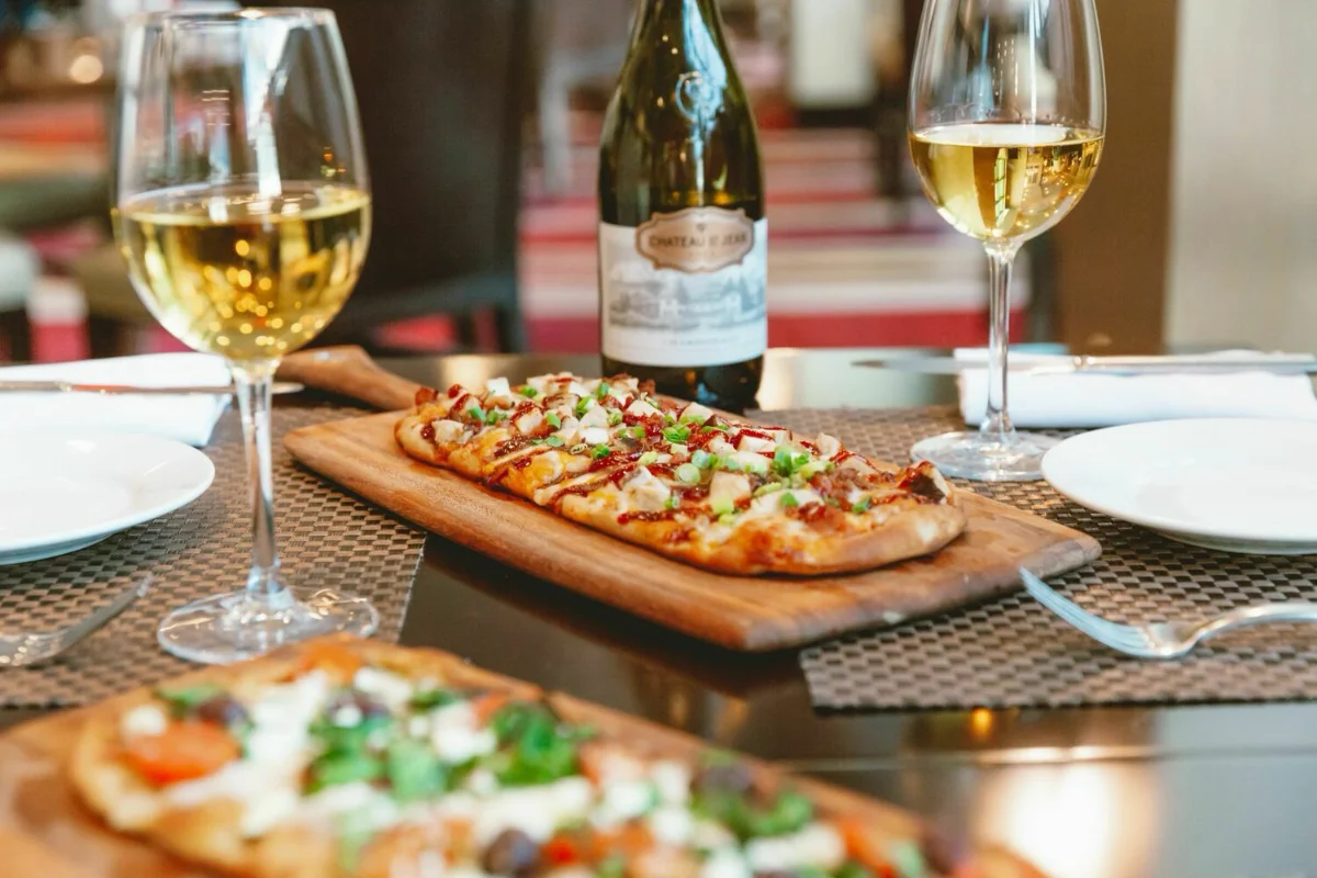 Flatbreads on wooden boards served with two glasses of white wine at Sagebrush