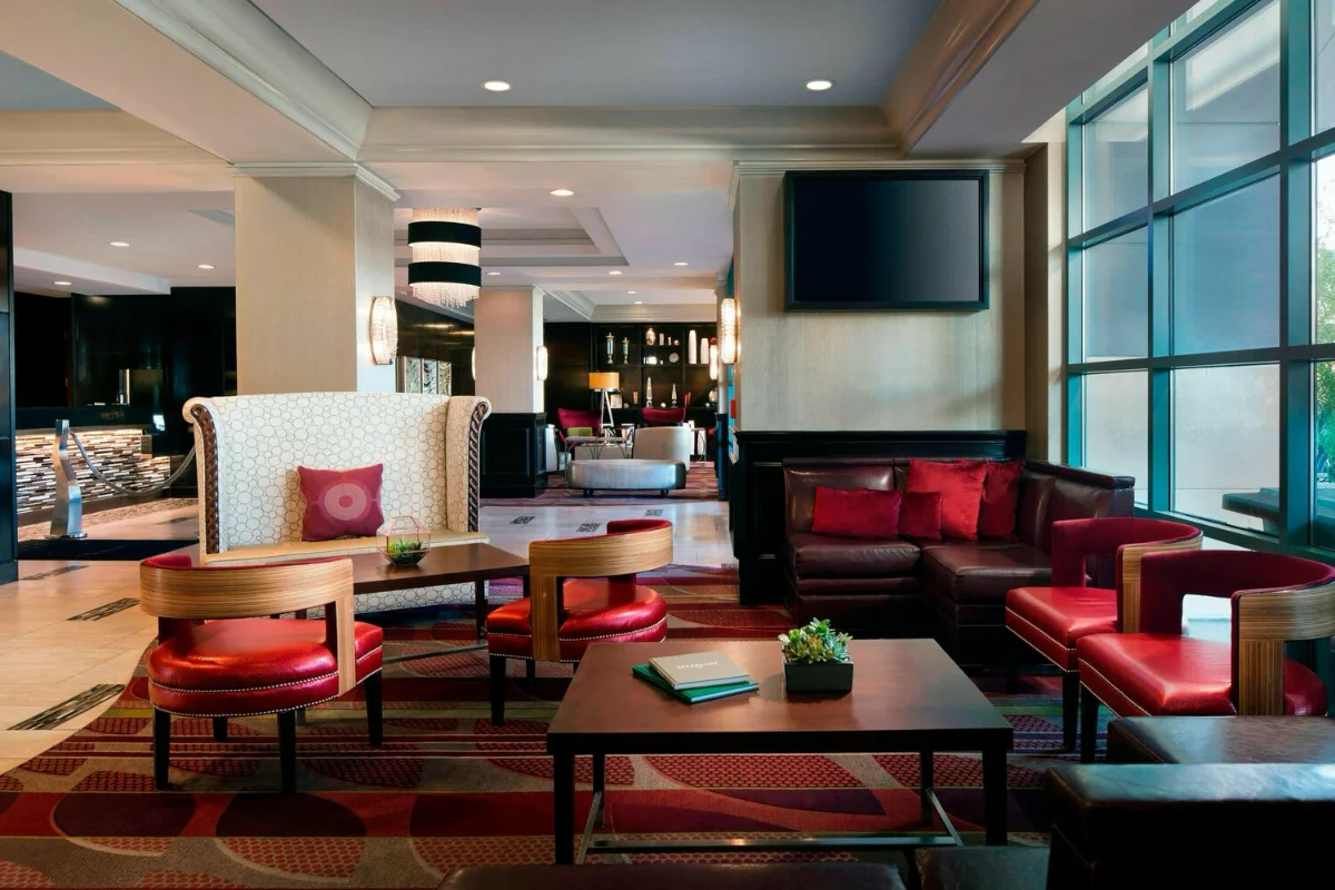 Lobby lounge with red leather armchairs, patterned carpet and floor-to-ceiling windows