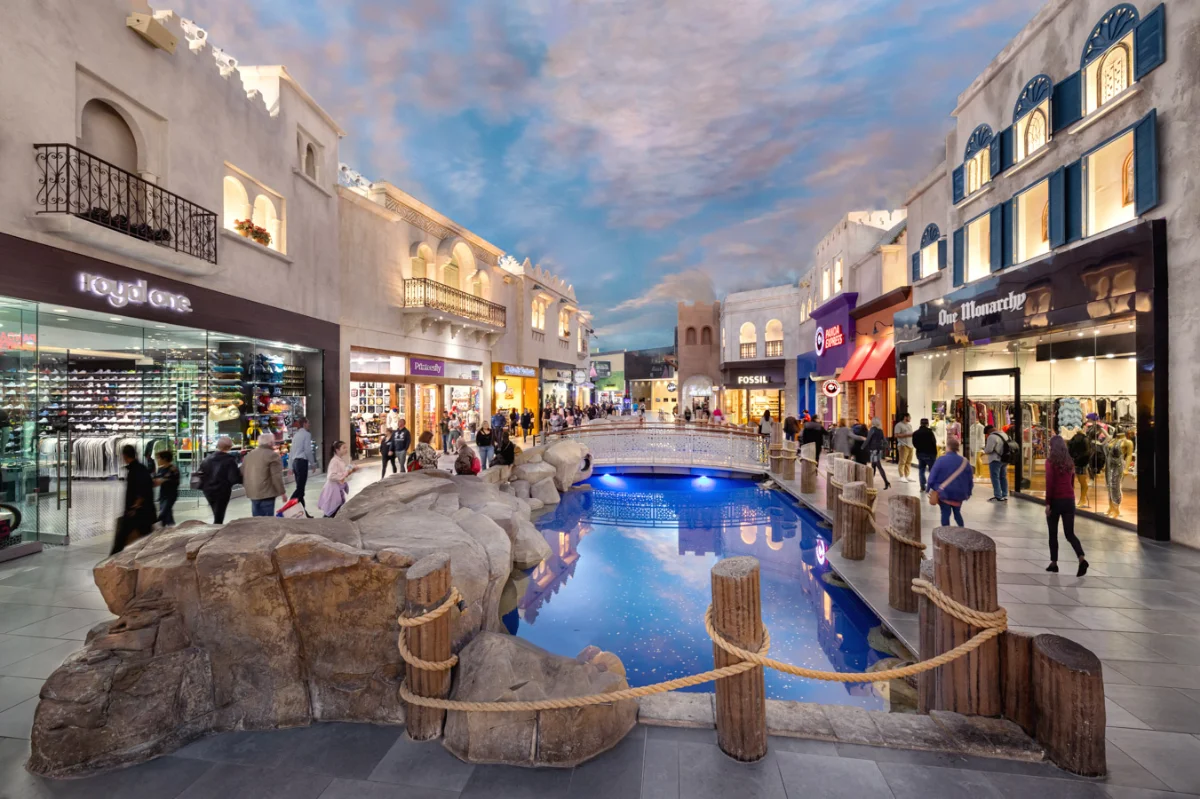 Indoor rock water feature and pool beneath a painted dusk-sky ceiling at Miracle Mile Shops