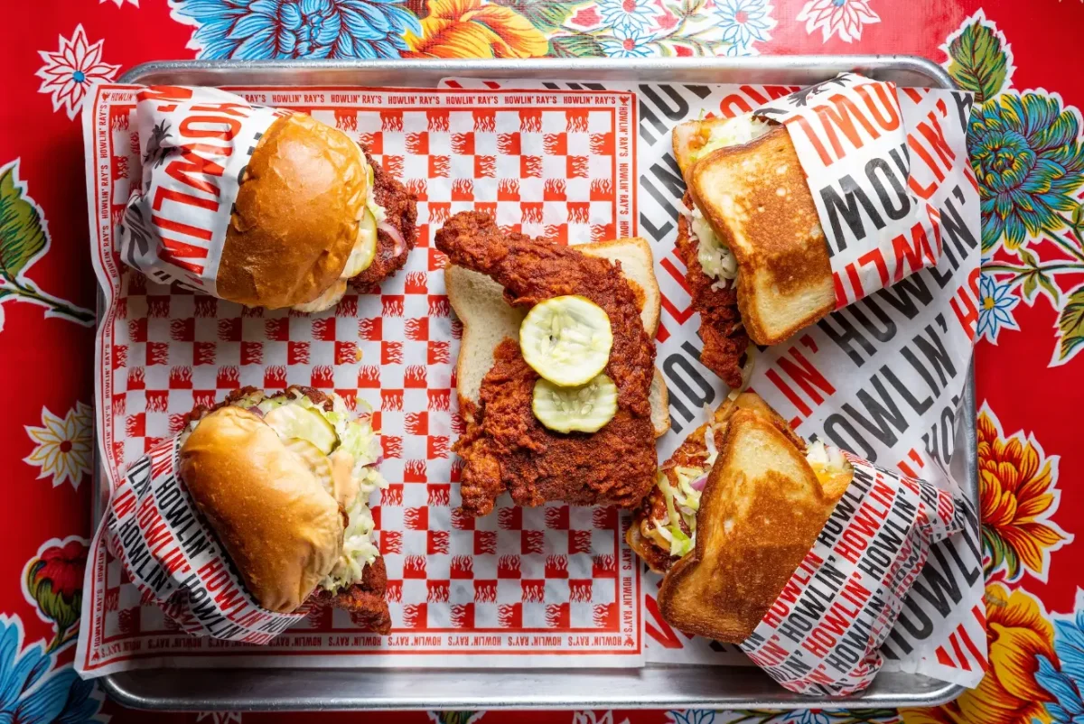Nashville hot fried chicken and sliders served on a checkered tray at Proper Eats Food Hall