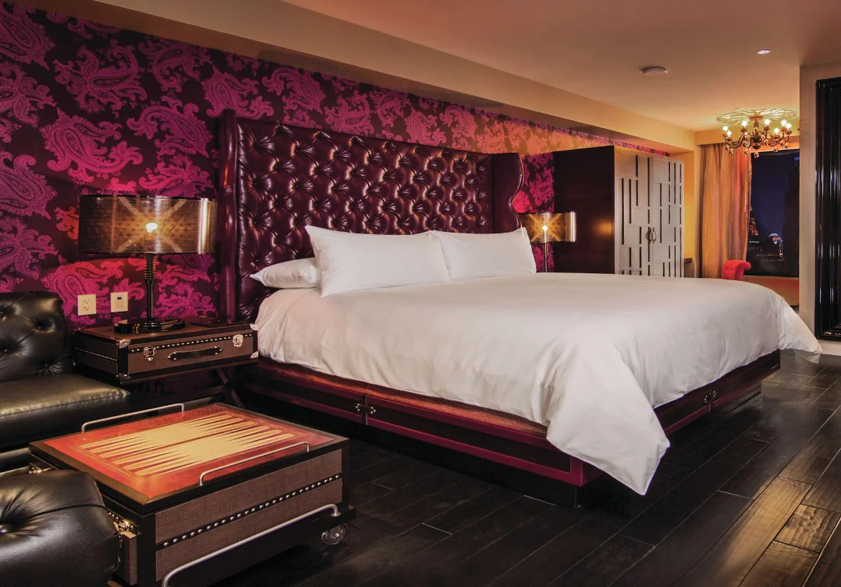 King suite with tufted leather headboard and pink paisley walls at The Cromwell