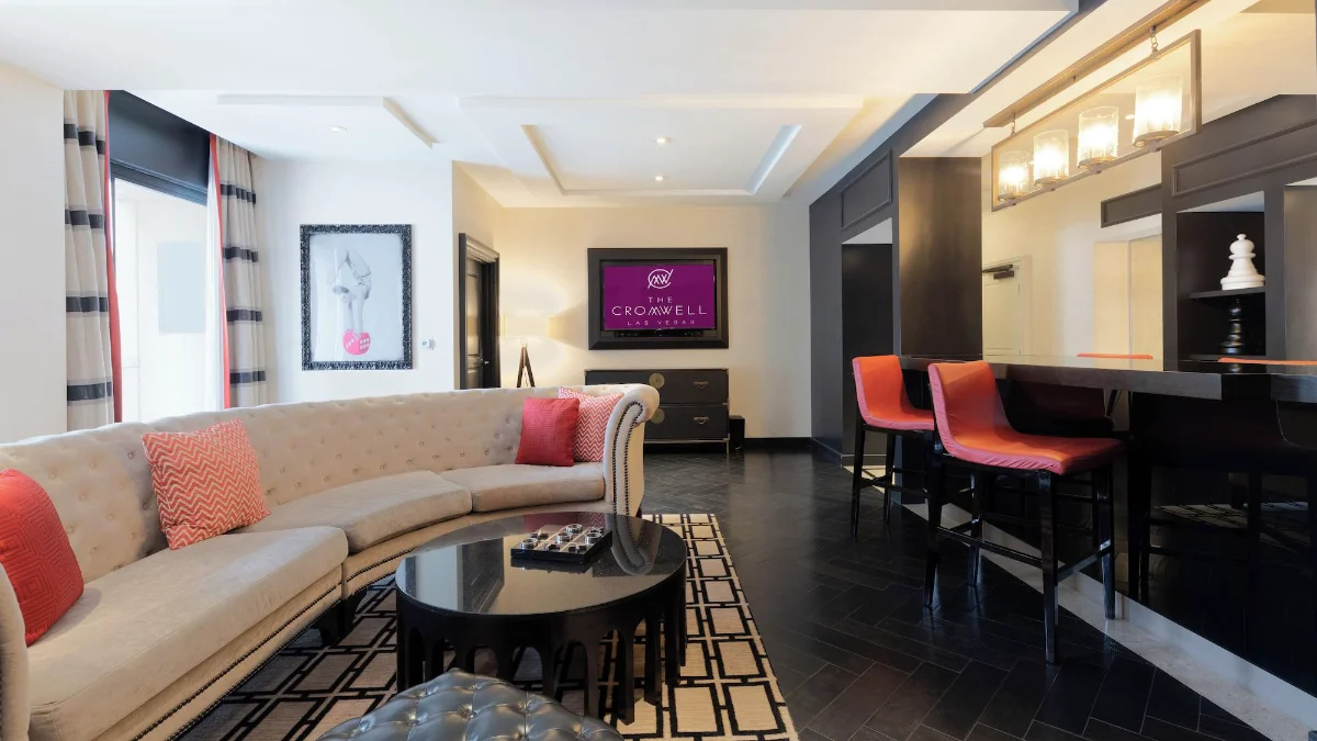 Suite living room with curved sofa and bar seating at The Cromwell