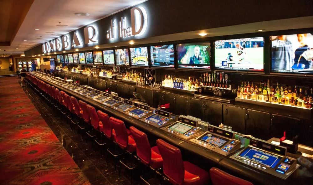 LONGBAR sports bar with red stools and TV wall at The D