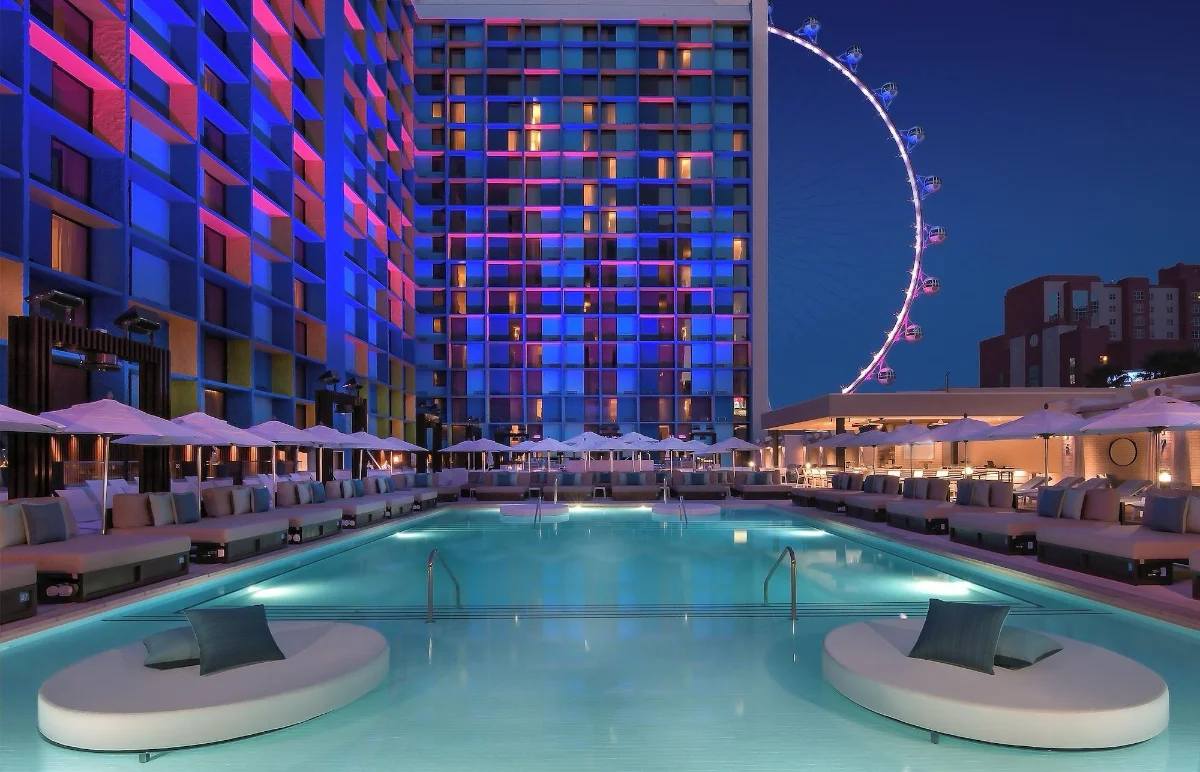 LINQ pool deck with daybeds and the High Roller lit at night