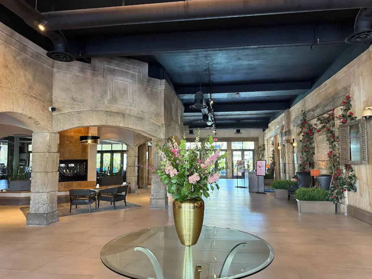 Stone-columned lobby with a floral arrangement at Tuscany Suites