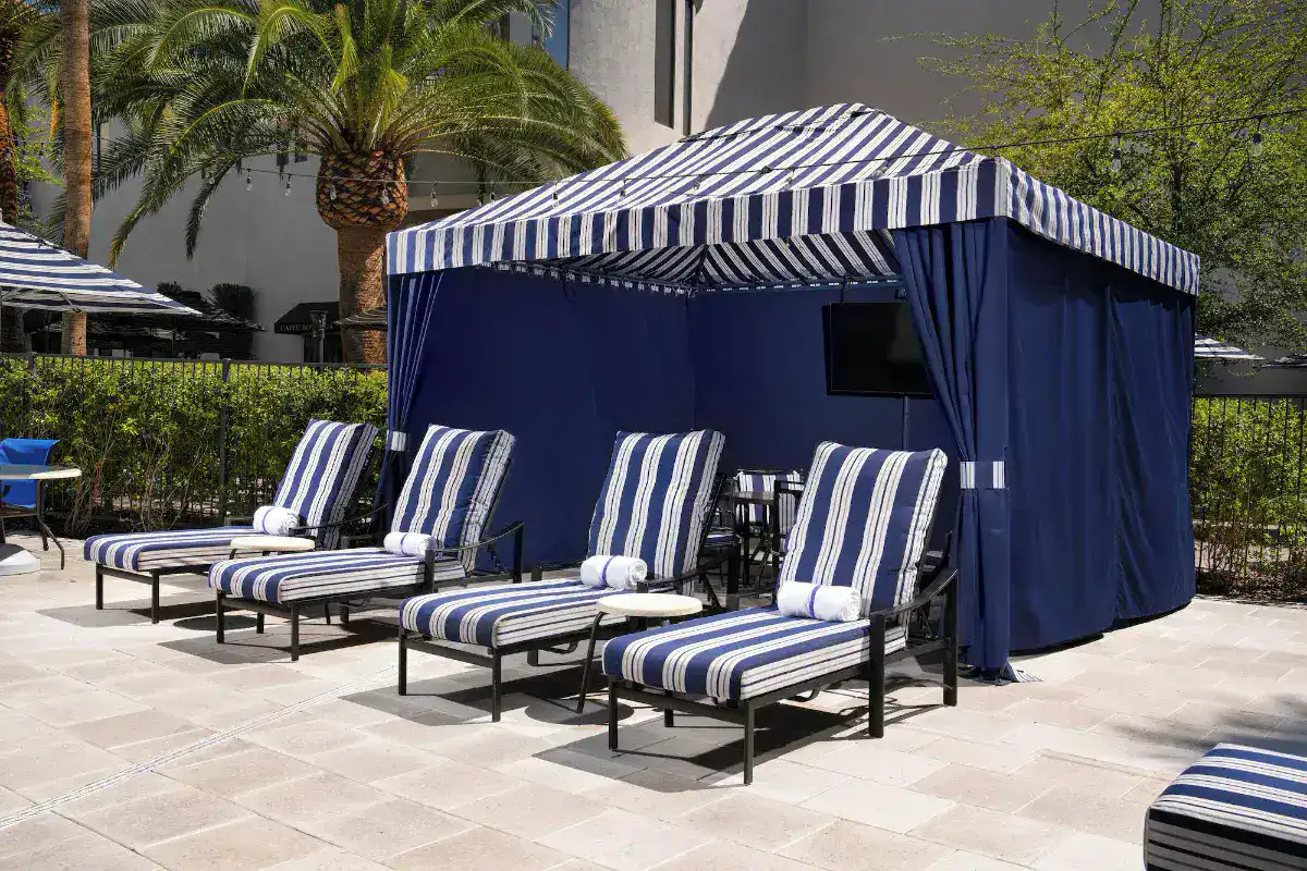 Poolside cabana with striped loungers at Tuscany Suites