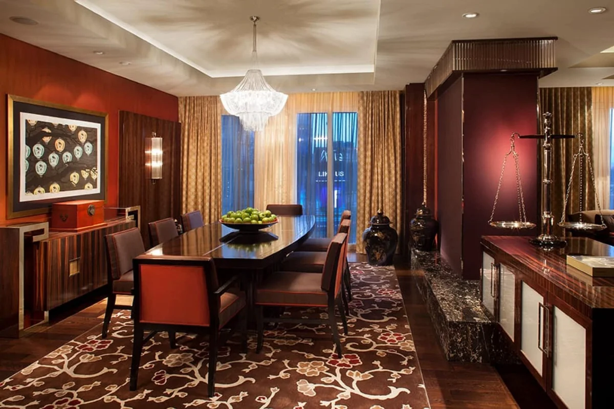 Formal suite dining room with chandelier and ornate rug at Waldorf Astoria